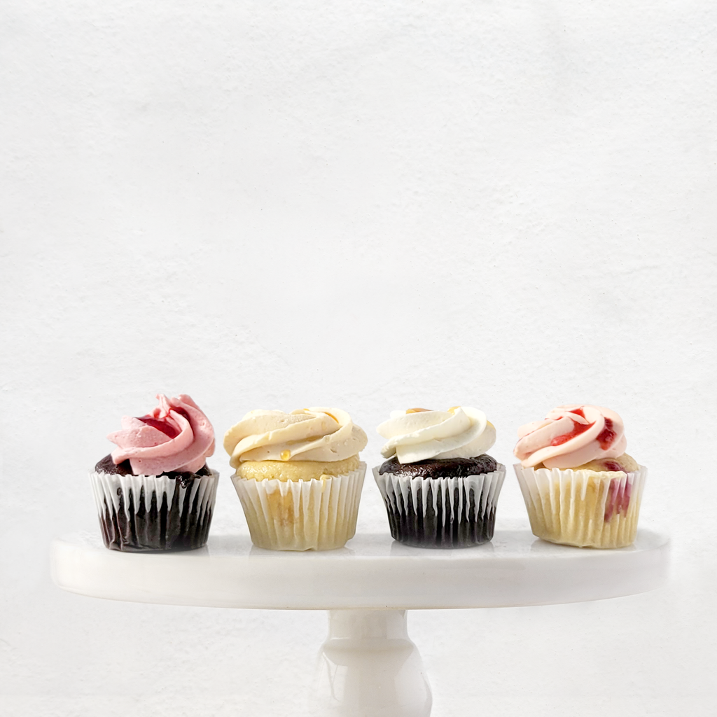 Lot de 4 mini cupcakes végane et sans allergènes vu de face. De gauche à droite : mini cupcake chocolat framboise, mini cupcake vanille érable, mini cupcake chocolat vanille et mini cupcake vanille framboise.